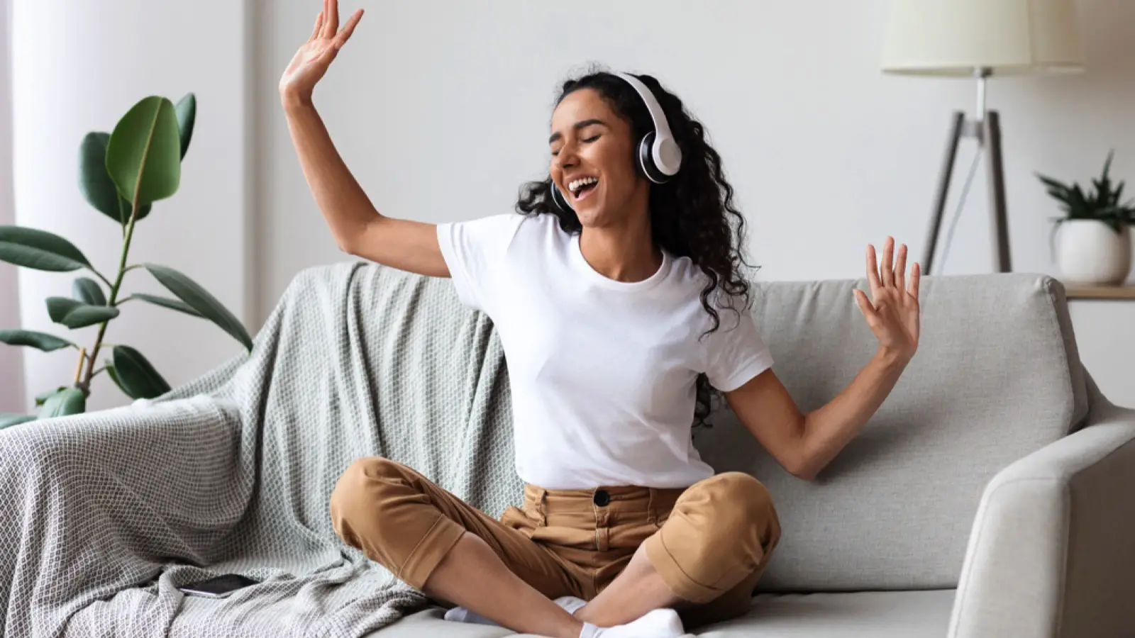 Woman in sofa listening to music and dancing